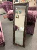 An ornate mirror in copper effect frame