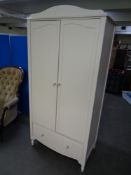 A contemporary painted double door nursery wardrobe fitted a drawer beneath