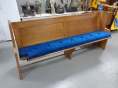 An oak church pew, with cushion,