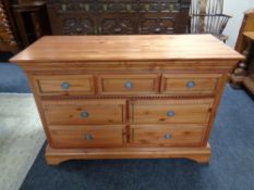 A contemporary pine seven drawer chest