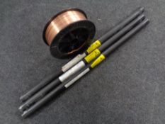 Three welding rods and a spool of welder's wire.