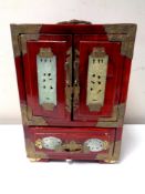 An oriental lacquered and hardstone inlaid cabinet