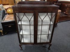 An Edwardian mahogany double door display cabinet on claw and ball feet
