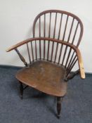 An antique elm stick back kitchen armchair