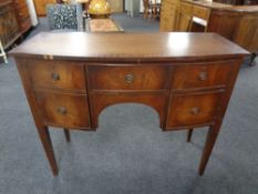 A mahogany bowfront sideboard on raised legs