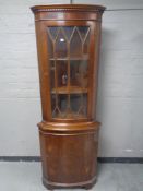 A glazed door corner cabinet fitted a cupboard below