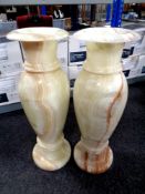A pair of onyx floor standing vases,