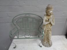 A concrete garden statue of a Thai figure and wrought metal miniature garden seat