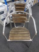 A set of four wooden and tubular metal stacking armchairs