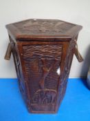 A carved hardwood hexagonal storage stool