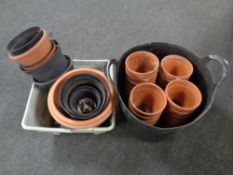 A plastic bucket containing a quantity of terracotta plant pots,