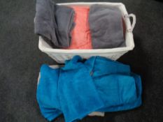 A large wicker basket containing assorted bath and hand towels
