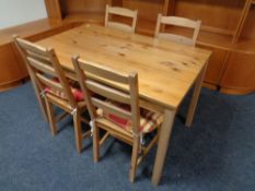 A pine kitchen table together with four chairs