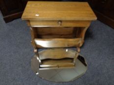 An oak magazine table fitted drawer together with an oval frameless bevel-edged mirror.