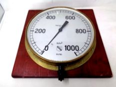 A circular air pressure gauge mounted on a board