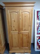 A contemporary pine double door wardrobe