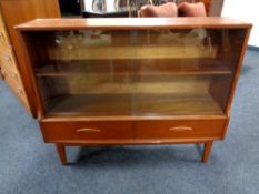 A mid century teak sliding glass door bookcase