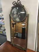 An antique gilt gesso bevelled mirror with colour print above surmounted with a bow