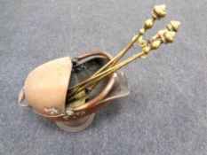 A Victorian copper coal helmet and three brass companion pieces