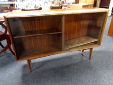 A mid century teak sliding glass door bookcase