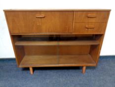A mid century teak sliding glass door bookcase fitted with two drawers and bureau