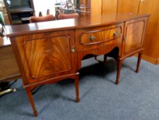 A Regency style mahogany serpentine fronted double door sideboard on raised legs