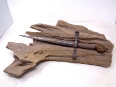 A medieval style dagger mounted on naturalistic stone base