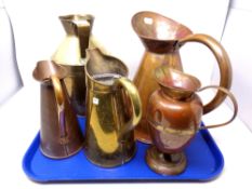 A tray of five brass and copper jugs