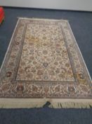 A Persian design fringed carpet.