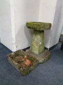 A concrete bird bath on plinth together with a further small bird bath.