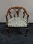 An Edwardian beech framed salon tub chair.