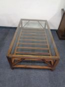 A glass topped contemporary coffee table with under-stretcher.