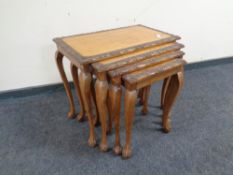 A carved walnut nest of four tables.