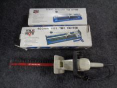 Two tile cutters in boxes together with a Ryobi hedge trimmer, no adaptor,