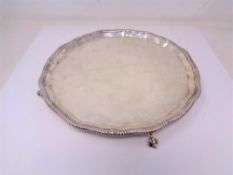 A silver card tray on claw and ball feet