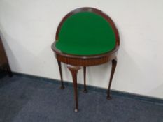 A reproduction mahogany D-shaped card table.