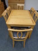 A contemporary light oak extending dining room table together with six chairs.