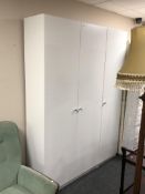 A contemporary white triple door wardrobe fitted internally with drawers.