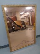 A copper tinted etched mirror in a gilt frame