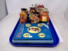 A tray of character jugs, two collecting books on toby jugs,