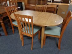 A contemporary rubberwood extending oval dining table and a set of four chairs