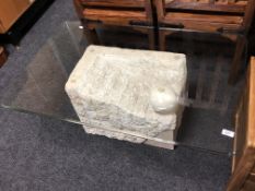 A contemporary rectangular glass topped coffee table on stone effect support
