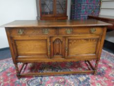 An oak sideboard fitted with cupboards and drawers beneath