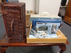 A wicker picnic hamper and a cased New Home electric sewing machine
