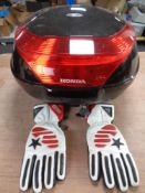 A Honda motorcycle storage box with keys and a pair of leather motorcycle gloves