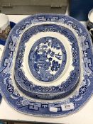 A 19th century willow pattern blue and white meat plate and two Woods ware willow pattern plates