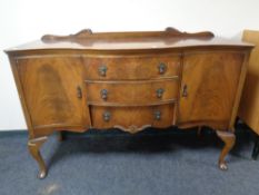 A walnut serpentine front sideboard fitted with cupboards and drawers with a matching extending
