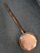 A copper beech handled bed warming pan