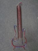 A metal CD storage rack in the form of a guitar