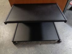 A contemporary two tier stand on castors